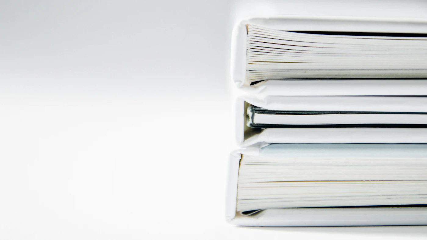 A stack of thick white binders