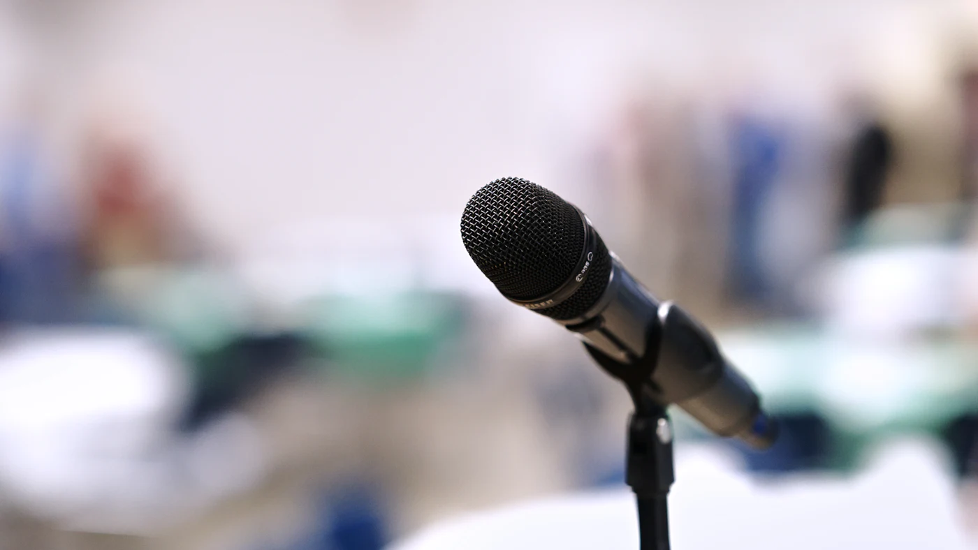 A microphone on a stand at a public meeting